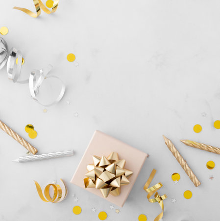 Creative Top view flat lay celebration background concept of birthday, anniversary, party, new year eve or christmas. Present box with golden bow, ribbons and confettiの写真素材