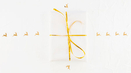 White gift box with golden ribbon on white background, copy space.の写真素材