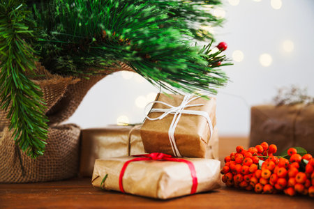 Christmas presents under the Christmas tree on a wooden table. Holidays background.の写真素材