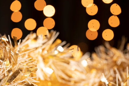 Christmas and New Year background with golden tinsel and bokehの写真素材