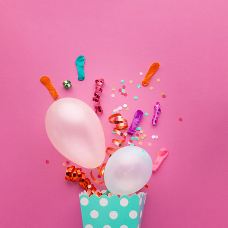 Colorful birthday balloons and confetti on pink background. Flat lay.の写真素材