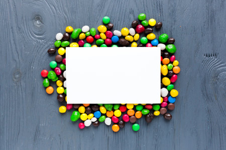 Colorful candies and blank card on wooden background. Top viewの写真素材