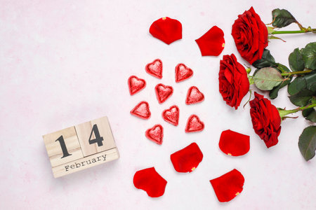 Valentine's day background with red roses and wooden calendar.