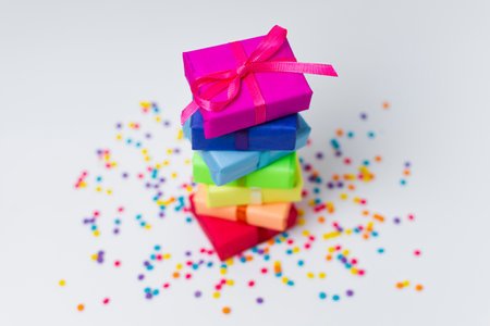 colorful gift boxes on a white background with multicolored sprinkles
