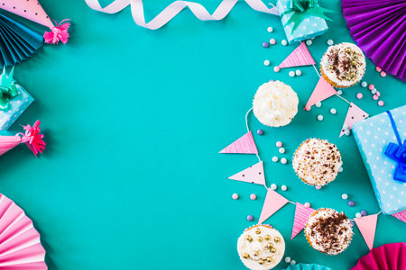 Birthday cupcakes with decorations on green background. Flat lay.の写真素材