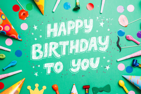 Happy Birthday to you text on green background with party accessories and confettiの写真素材