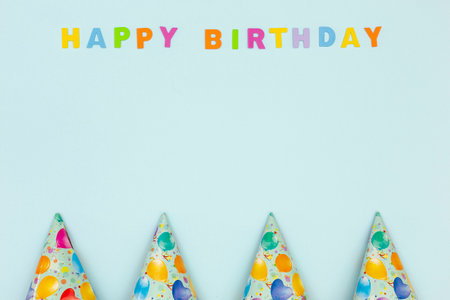 Happy birthday card with colorful paper party cones on pastel blue backgroundの写真素材
