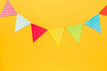 Colorful party flags on yellow background. Flat lay, top viewの写真素材
