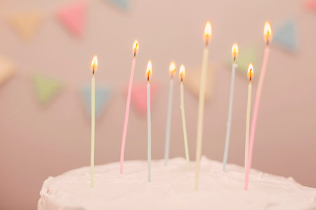 Birthday cake with candles on pink background, shallow depth of fieldの写真素材