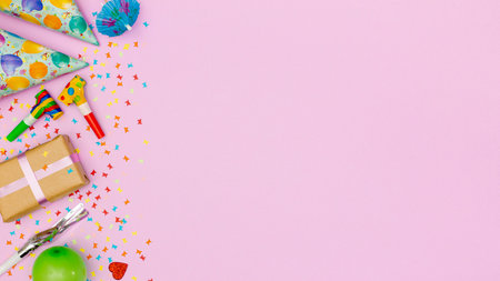 Birthday party background with gift box, confetti and party items on pink backgroundの写真素材
