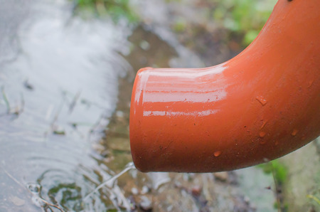 Rain water flowing from drain pipe closeupの写真素材