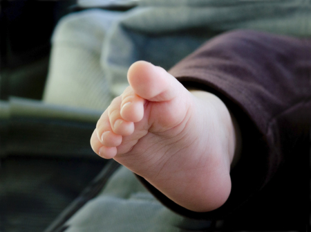 Baby foot and toes on a bedの写真素材