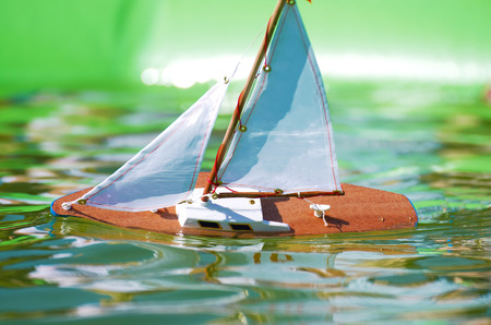 Traditional small wooden sailing boat in the pond of parkの写真素材