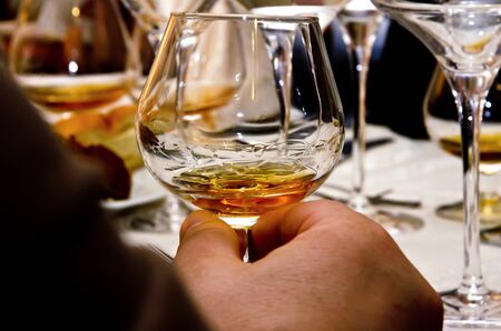Alcoholism.Brandy or cognac in the hand of an alcoholic.の写真素材