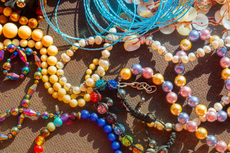 a lot of costume jewelry with different materials on a black background in. High quality photo