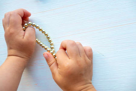 hands of child play with gold jewelry and bijouterie, on white background. concept of womens happines High quality photoの写真素材