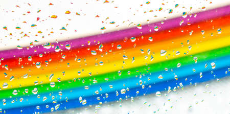 abstract colorful diagonal rainbow background with water drops on a glass with bubblesの写真素材