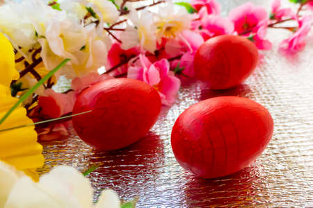 Easter card with painted red Easter eggs and flowers on a silver background. Decorated with painted...