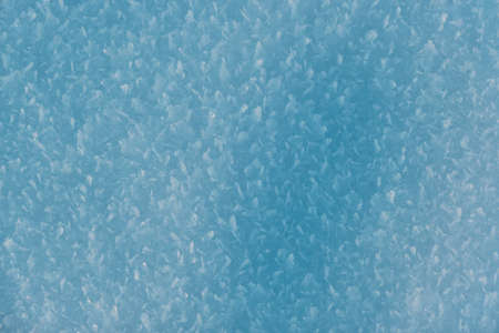 Snow texture with snowflakes close-up. Snow background for Christmas card or wallpaper. Blue macro...
