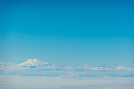 Aerial view over Elbrus, Karachay Cherkessia. the sky with clouds, below the level of the top of Elbrus. A mountain like a cloud. high quality photoの写真素材
