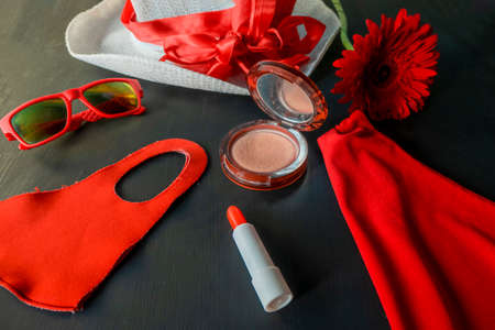 flat lay of a fashionable look from red and white accessories on a black background. A scarlet dress...