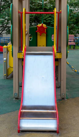 An element of a children's swing. slide. An outdoor colorful playground next to the house. A summer...