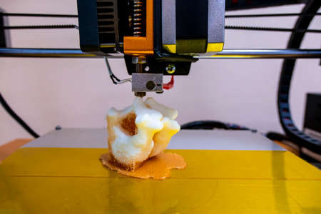 printing vertebrae on a 3d printer. artificial body parts printed on a 3d printer. New era of medicine. printing on a 3d printer. orange trident is printed with plastic on a 3d printerの写真素材