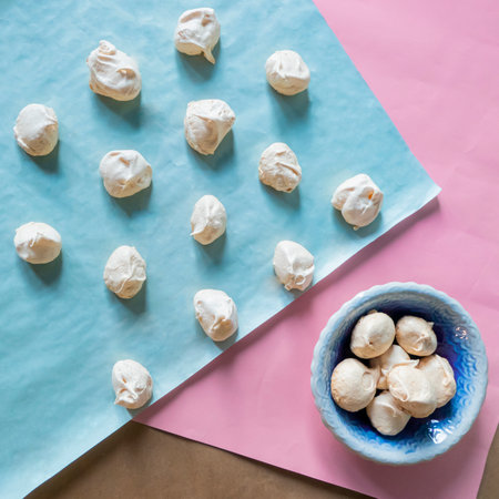 Homemade french milk-colored meringues on bluet paper. flatley composition: delicious homemade meringues on craft paperの写真素材