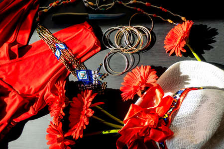flat lay of a fashionable look from red and white accessories on a black background. Scarlet dress...