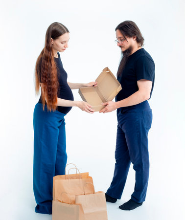 Portrait happy young pregnant woman and her husband with shopping bags and touching her big belly...