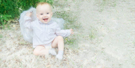 Portrait of a beautiful little happy girl With white angel wings in nature, picnic, family. High quality photoの写真素材