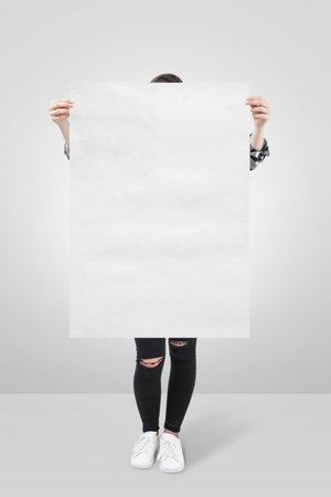 A Woman Holding an Empty Poster Mockupの写真素材