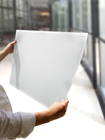 A Woman Holding an Empty Poster Mockupの写真素材
