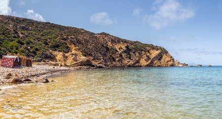 Deserted Haven: Ain Kanassira's Beach Nestled Between Sea and Mountains in Tunisia.の写真素材