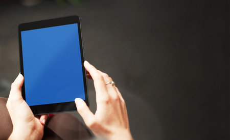 Hand holding tablet with blank screen