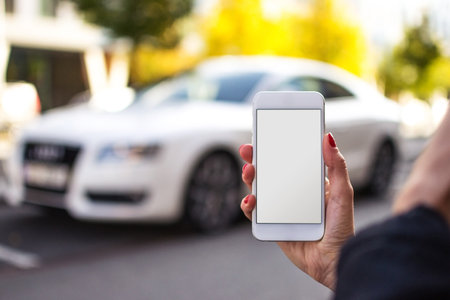 Mobile phone mockup with blank screen on white background for advertising, featuring a hand