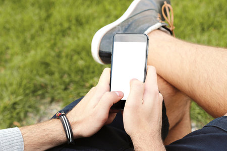 Mobile phone mockup with blank screen on white background for advertising, featuring a handの写真素材