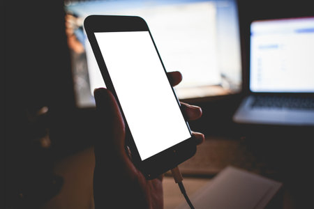 Mobile phone mockup with blank screen on white background for advertising, featuring a handの写真素材