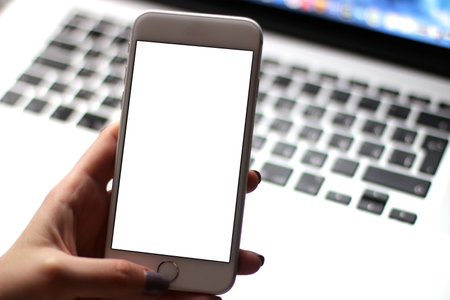 Mobile phone mockup with blank screen on white background for advertising, featuring a hand