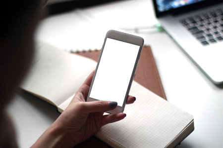 Mobile phone mockup with blank screen on white background for advertising, featuring a handの写真素材