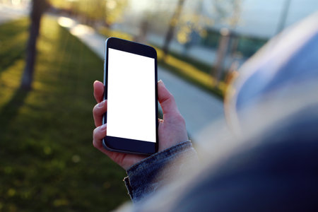 Hand holding a mobile phone mockup with a blank screen