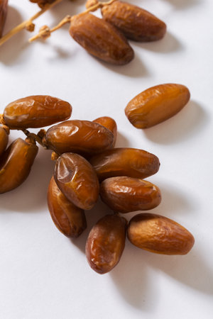 Fresh organic dates displayed on a white background, showing their natural golden-brown color and...
