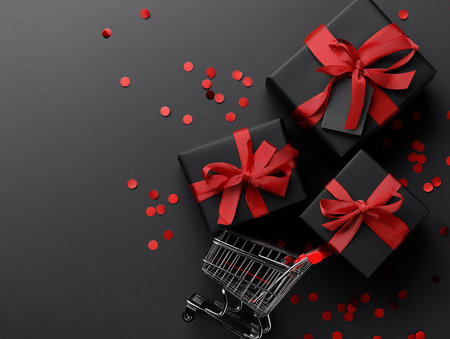 Black Friday flat lay with black gift boxes, red ribbons and shopping cartの素材