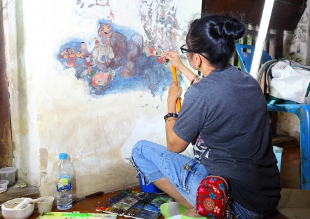 AYUTTHAYA, THAILAND - AUGUST 2 : The artist painter is repairing the ancient mural paint on the wall  which damaged from flood in Ayutthaya at Choengta temple on August 2,2012 in Ayutthaya, Thailand のeditorial素材