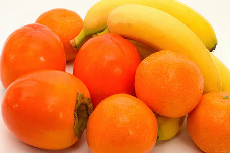 Still life with tangerines, bananas and kakiの写真素材