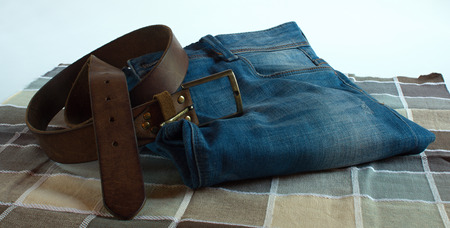 Blue jeans brown belt on checkered fabricの写真素材