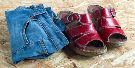 red shoes and blue jeans on plywood backgroundの写真素材