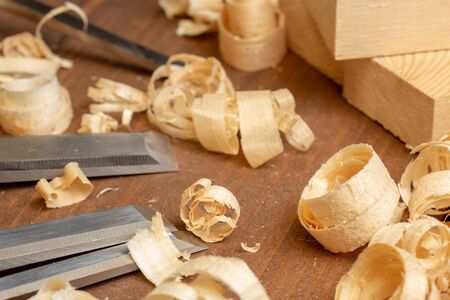Chisel with wood shavings. Carpenter cabinet maker hand tools on the workbench.