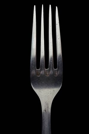 Fork close up. Isolated image on a black background.の写真素材