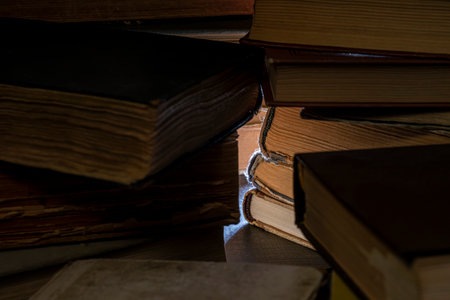 Stacks of old multi-format books with scuffs. Low depth of field photography